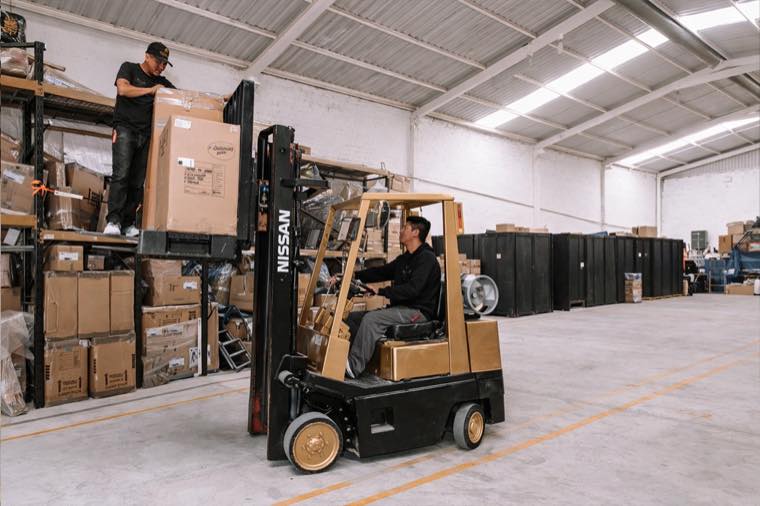 A forklift moving a pallet in the qübo warehouse.
